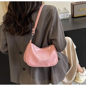 Detail der rosa Lackleder-Baguette-Tasche mit Schmetterlings-Prägung und Schultergurt