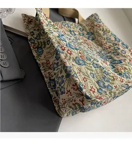 Detail of floral jacquard woven fabric and wide beige straps on a square tote bag
