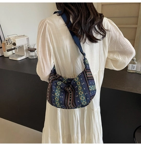 Sac bandoulière ethnique en toile aux motifs géométriques porté par un mannequin dans un café