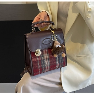 Detail of vintage plaid拼接 backpack with golden lock and cute plush monster charm