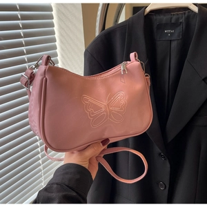Detailansicht der rosa Baguette-Tasche mit Schmetterlingsstickerei und Metallreißverschluss