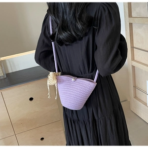 Detail of purple woven shoulder bag with pearl buckle and knit charm decoration
