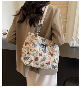 Detail of a butterfly print tote bag with metal chain strap and spacious interior