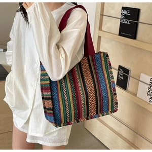 Detail of colorful geometric woven patterns and red handle on ethnic canvas tote bag