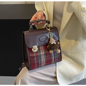 Detail of vintage plaid handbag with brown leather trim and cute plush charm pendant