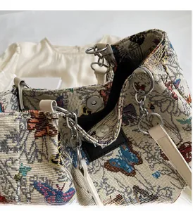 Detailed close-up of butterfly jacquard fabric and silver metal buckle on the handbag