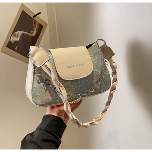 Détail du sac en jacquard floral avec bandoulière tressée et chaîne fleurie argentée