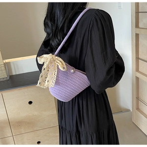 Detail of hand-woven purple shoulder bag with delicate lace bow and pearl buckle detail
