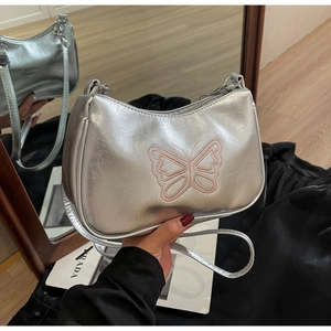 Detail der silbernen Lackleder-Schultertasche mit besticktem rosa Schmetterling-Motiv