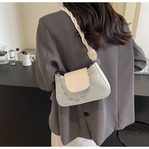 Détail du sac à bandoulière en jacquard bleu clair avec rabat en cuir et chaîne