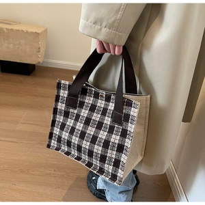 Close-up of canvas tote bag with black and white grid pattern and fabric handles