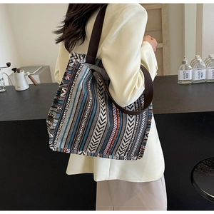 Detailed view of large ethnic woven tote bag with colorful geometric stripes and wide strap