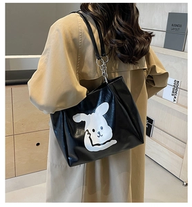 Detail of black PU leather tote bag with white cartoon animal print and silver chain