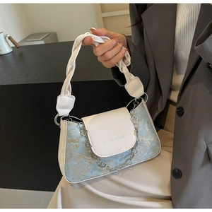 Gros plan sur le tissu jacquard floral et la poignée en cuir tressé du sac à main