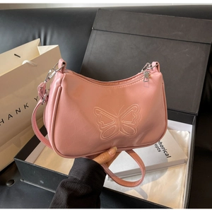 Detailansicht der rosa Baguette-Tasche mit Schmetterlingsstickerei und Wachsleder-Textur