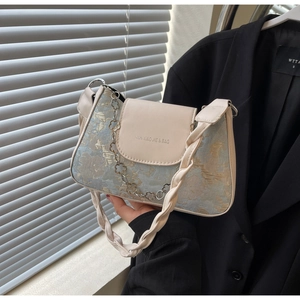 Détail du sac jacquard floral avec poignée tressée et chaîne métallique en fleurs