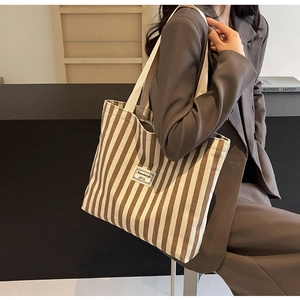 Braun-weiß gestreifte Canvas-Einkaufstasche, getragen mit einem grauen Business-Blazer