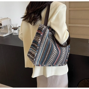 Close-up of woven ethnic tote bag with colorful geometric patterns and brown strap