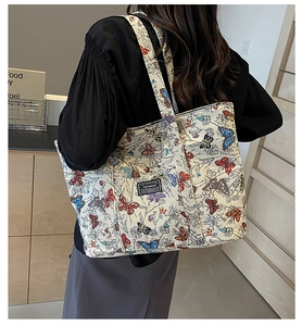 Detailed side view of high-capacity canvas tote bag with butterfly prints and fashion label