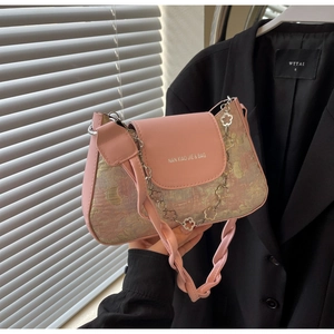 Détail du sac à bandoulière rose avec chaîne en métal floral et lanière en cuir