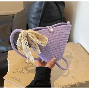 Detailed close-up of lavender woven bag with pearl buckle and lace bow decoration