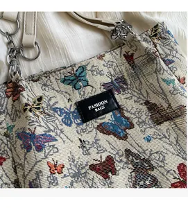 Detail of floral butterfly jacquard tote with gold chain strap and fashion logo tag