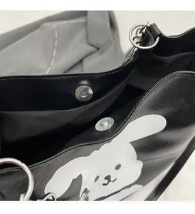 Detail view of the glossy black tote bag showing magnetic closure and silver hardware