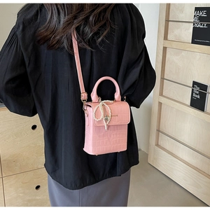 Detail showing pink crocodile texture mini crossbody bag with elegant pearl fringe tassel