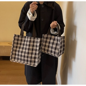 Close-up of black and white plaid tote bags in two sizes with textured tweed fabric