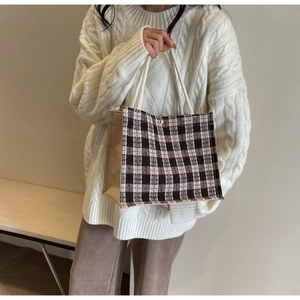 Detail of vintage plaid tote bag with woven rope handles and metallic magnetic clasp