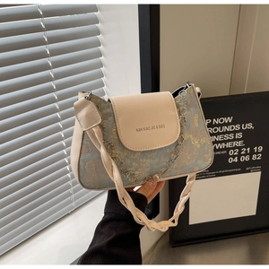 Détail du sac baguette en jacquard bleu clair et cuir avec poignée tressée
