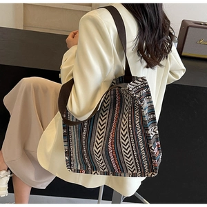 Detailed view of large ethnic woven tote bag with colorful geometric patterns and wide strap