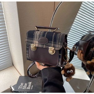 Detailed macro view of vintage plaid pattern and premium leather texture with gold buckles