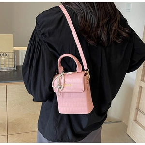 Pink crocodile-embossed mini crossbody bag with pearl heart charm and golden logo
