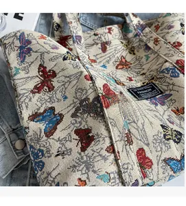 Detail of colorful butterfly embroidery on thick off-white canvas tote bag with fashion tag