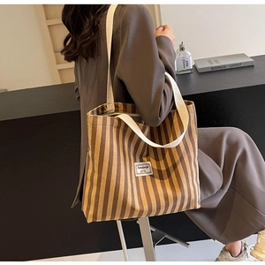 Detail der gestreiften Cord-Tasche mit Stoffstruktur und Markenetikett-Ansicht