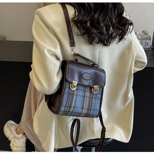 Detail showing the retro plaid pattern and gold buckles of the convertible backpack