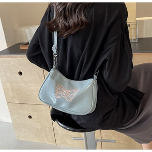 Verstellbare Trageriemen einer hellblauen baguette tasche mit rosa Schmetterlingsstickerei