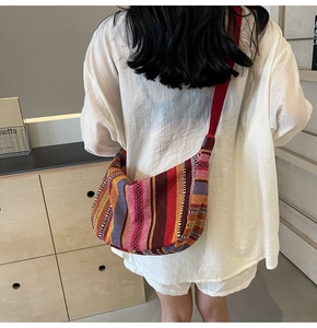 Grand sac bandoulière bohème à rayures colorées tissées porté par le mannequin