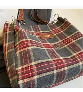 Close-up of wool-like plaid tote bag fabric with fashion leather label and metal ring