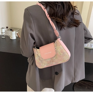 Détail du sac épaule en tweed rose avec chaîne florale porté sur un blazer gris chic