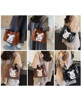 Detail showing cartoon rabbit tote bags with metal chain straps worn in different colors