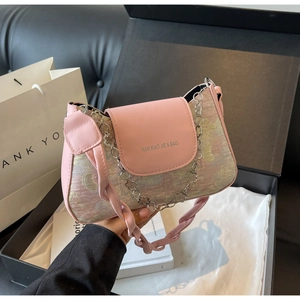 Détail d'un sac sous le bras en jacquard rose avec chaîne pétale argentée en coffret