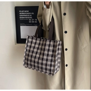 Close-up of brown and beige checkered tote bag with reinforced handles and texture