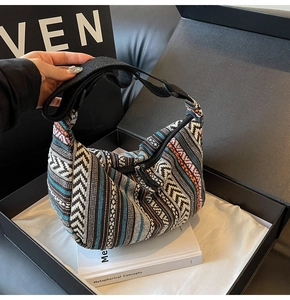 Gros plan détaillé du sac hobo ethnique aux motifs tissés colorés en boîte cadeau