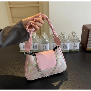 Détail du tissu jacquard rose avec chaîne à fleurs sur le sac baguette français