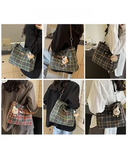Detail view of stylish plaid tote bags with leather straps and plush charms in various colors