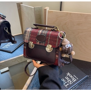 Detail of vintage plaid handbag featuring dual gold locks and a cute plush doll charm