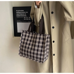 Close-up of a brown checkered tote bag with wide handles for daily commuting and fashion