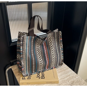 Detail of ethnic geometric woven texture on large capacity tote bag with brown straps